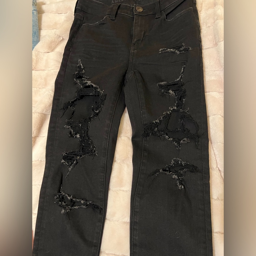 American Eagle. Black stretchy jeans…fashion cut holes through out legs.